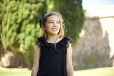 Siyah elbiseli, yakışıklı, düşünceli bir kız. Gözlerini kaçırıyor, dudaklarını ısırıyor. Hoş bir poz düşünüyor. 