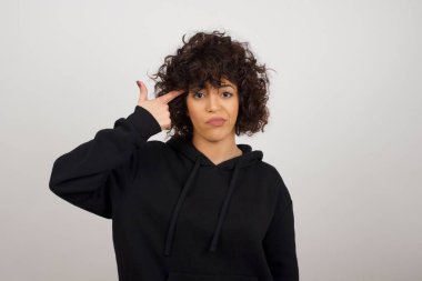 Mutsuz kadın silah hareketi yapıyor, her şeyden bıkmış, sinagogda elle çekim yapıyor, stüdyo arka planında izole edilmiş..