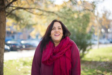 Parkta gülümseyen orta yaşlı güzel bir Arap kadın.  