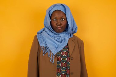 Komik komedyen Afrikalı Amerikalı Müslüman kadın gözlerini şaşı yapar, dudaklarını buruşturur, bütün gün çalıştıktan sonra suratını buruşturur. Tuhaf ifadeli cahil kadın inek tek başına eğleniyor, aptalı oynuyor..