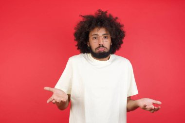 Kızıl duvarda afro saçlı kafası karışık genç adam.   