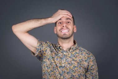 Tüh, ne yaptım ben? Yakışıklı sarışın adam, korkmuş ve pişmanlık dolu bir ifadeyle alnından el ele tutuşuyor. Açık havada günlük giysiler giyerek..