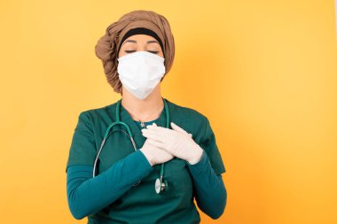 Sadık, genç, güzel, yeşil üniformalı Müslüman doktor gözlerini kapatıyor ve ellerini kalbine yakın tutuyor, şefkatini ya da iyiliğini gösteriyor, samimi duygularını dile getiriyor, iyi kalpli ve dürüst oluyor. Vücut dili ve gerçek duygular kavramı.