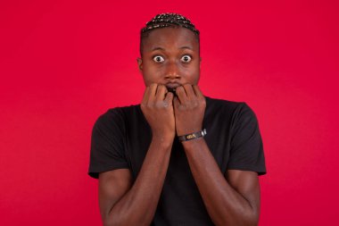 Endişe. Güzel bir Afro-Amerikan erkeğinin kavramsal görüntüsü. Ağzını ellerle kaplayan ve içeride duran. Bir şeyden ya da birinin çivi yemesinden korktun mu?.