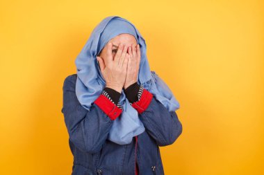 Endişe. Orta yaşlı, tesettürlü, güzel bir müslüman kadının kavramsal görüntüsü. Yüzü elleriyle örtülmüş ve bir gözü kapalı dışarı bakıyor. Bir şeyden ya da birinden korktun mu?.