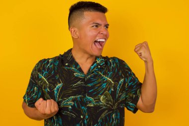 Çekici, genç İspanyol bir adam zaferi kutluyor yumruklarıyla havaya yumruk atıyor ve stüdyo arka planında fotokopi çekerek dişlek bir gülümseme yayıyor..