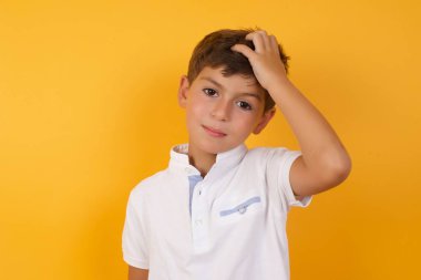 Sarı duvara karşı düşünen tatlı çocuk.  