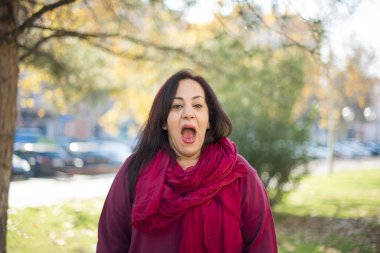 Parkta ağzı açık, orta yaşlı, güzel bir Arap kadın.  