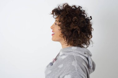 Pijamalı gülümseyen kadın profili kopya alanı olan beyaz stüdyo duvarından izole edilmiş.