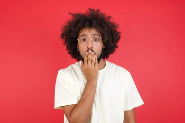 Confuso Joven Con Pelo Afro Contra Pared Roja — Foto de Stock