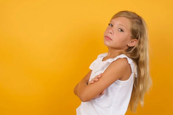 cute  girl with arms crossed    on yellow background