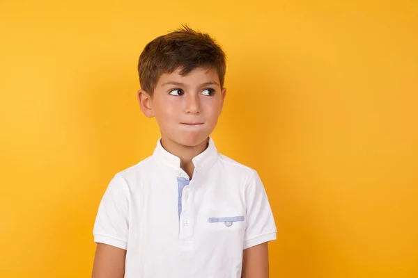 Menino Bonito Olhando Para Longe Contra Parede Amarela — Fotografia de Stock