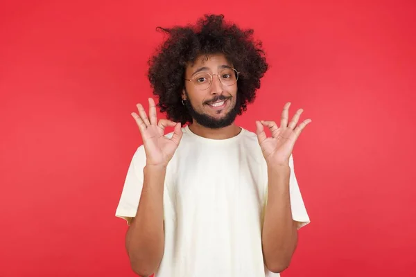 Junger Mann Mit Afrohaaren Zeigt Okay Gegen Rote Wand — Stockfoto
