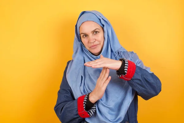 疲れて退屈なヒジャブの中年のイスラム教徒の女性は タイムアウトのジェスチャーを作り 仕事のストレス 時間の概念のために停止する必要があります 壁に立ち向かう — ストック写真