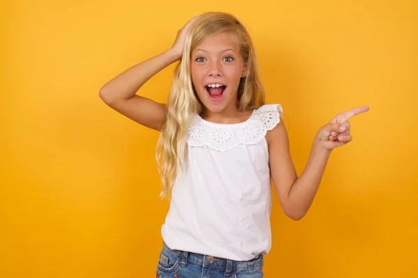 Bonito Menina Vestido Rosa Contra Amarelo Estúdio Fundo Apontando — Fotografia de Stock