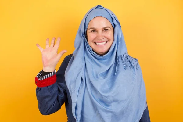 Muzułmanka Średnim Wieku Hidżabie Stojąca Przy Ścianie Pokazująca Wskazująca Palcami — Zdjęcie stockowe