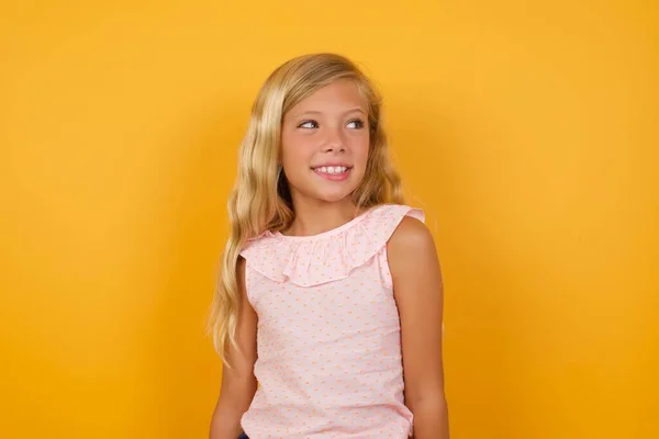 Мила Маленька Дівчинка Рожевій Сукні Жовтому Студійному Фоні Дивлячись Далеко — стокове фото
