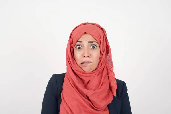 美丽的穆斯林女人穿着黑色外套 头戴头巾 神经质 害怕地咬着嘴唇 带着不耐烦的表情和沉思的表情看着相机 — 图库照片