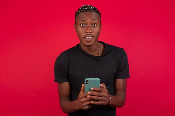 Hombre Afroamericano Vistiendo Camiseta Negra Sobre Fondo Rojo Vez Atención — Foto de Stock