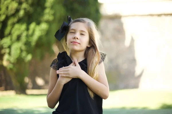 Faithful Cute Girl Black Dress Closes Eyes Keeps Hands Chest — Stock Photo, Image