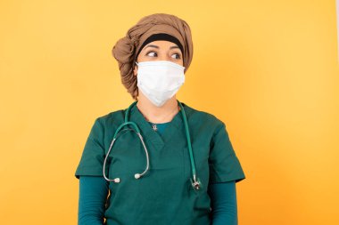 Hayalperest, genç, güzel, Müslüman, yeşil üniformalı, düşünceli bir kadın, başka tarafa bakıyor. 