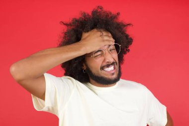 Kızıl duvarda saçları olan genç bir adam. 