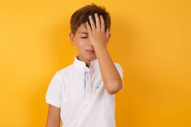 Sarı duvarda eli yüzü olan sevimli bir çocuk.  