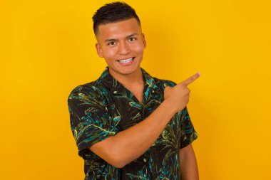 Yakışıklı adam seni işaret ediyor ve sana gülümsüyor sarı arka planda dururken.