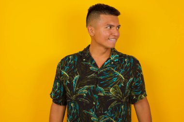 Hayalperest, genç İspanyol bir adam, düşünceli bir yüz ifadesi var, ellerini aşağıda tutuyor, dudaklarını ısırıyor, gri duvara karşı hoş bir poz düşünüyor..