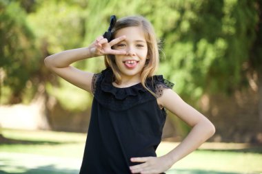 İnsanların flört konseptini kutladıkları boş bir yaşam tarzı. İçeride dikilen günlük giysiler giymiş, gözlerinin yanında V işareti olan güzel bir kız..