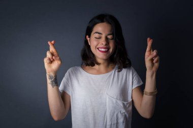 Kazanmak zorundayım. Neşeli genç esmer kadın dişlerini sıkar, parmaklarını çapraz yapar, arzulanan dilekleri yapar, günlük kıyafetler giyer, iyi haberleri bekler, gri duvarın üzerinde durur.