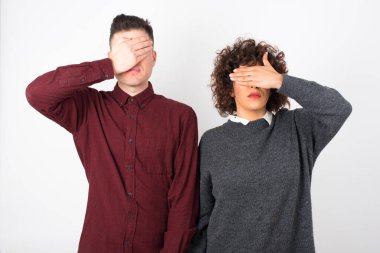 Stüdyo çekimi. Genç ve güzel çift gözlerini kapatıyor. 