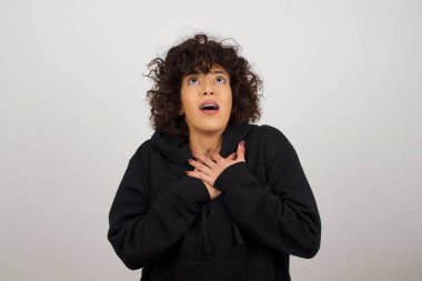 Mutlu sürpriz kadının elleri göğsüne yakın. Genç, duygusal bir kadın. İnsani duygular, yüz ifadesi kavramı. 