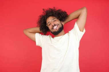 Kızıl duvarda gülümseyen afro saçlı genç adam.   