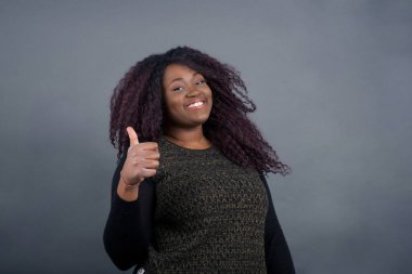 İyi iş! Mutlu gülümseyen Afro-Amerikan kadın portresi gündelik giysiler içinde başparmak hareketi yapıyor. 