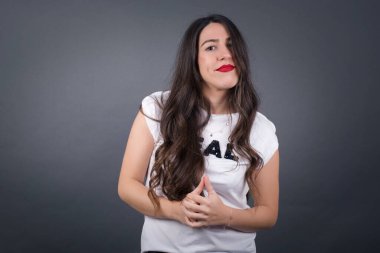 Gri arka planda düşünen güzel bir kadın.  