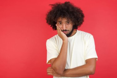 Kızıl duvarda saçları olan genç bir adam.   