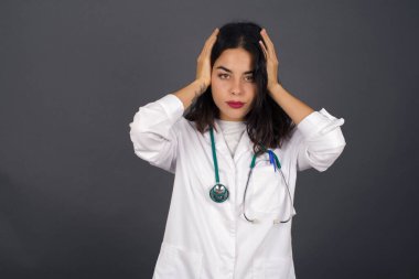 Elleriyle kulaklarını tıkayan doktor kadın hard rock veya yüksek sesle müzik dinlemek istemiyor. Avrupalı genç doktor gürültüyü ya da gürültüyü görmezden geliyor ya da elleriyle kulaklarını kapatıyor sokakta yüksek seslerden kaçınıyor.