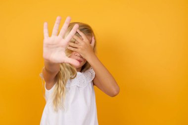 Sarı arka planda hayır diyen sevimli bir kız. 