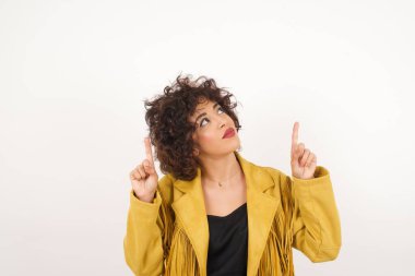 Başarılı, dost canlısı, parlak makyajlı, parlak saçlı bir kadının işaret parmağıyla işaret ederek boş bir fotokopi duvarında şok edici bir şey gösterdiği yatay bir görüntü..