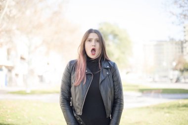 Parkta ağzı açık genç ve güzel bir kadın.