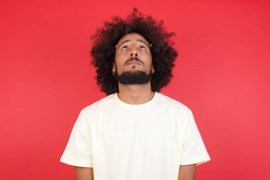 Kızıl duvara bakan afro saçlı genç adam. 