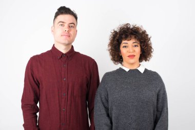 İzole edilmiş arka planda genç ve güzel bir çift gülen yüzler.