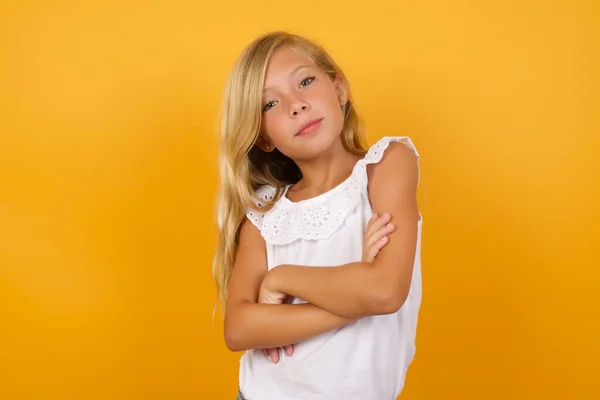 黄色の背景で腕を組んでかわいい女の子 — ストック写真
