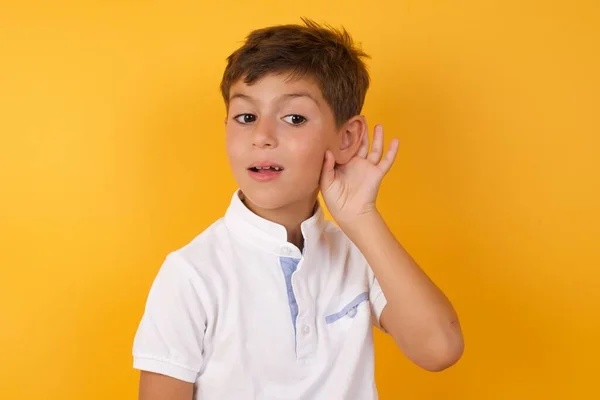Roztomilý Chlapec Poslouchá Proti Žluté Zdi — Stock fotografie
