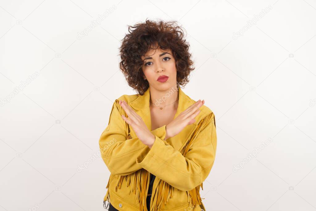 Beautiful  woman in suede jacket  gesturing stop studio shot