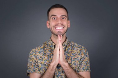 Güzel bir adamın yatay portresi avuç içlerini bir arada tutar, mutlu bir ifadesi vardır. Çekici bir erkek merhamet diliyor. Umutlu genç yetişkin.