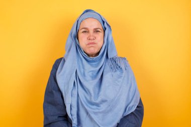 Güzel, orta yaşlı, tesettürlü, komik yüzlü Müslüman kadın. Havayla şişmiş ağız, çılgın bir ifade..