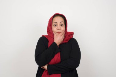 Endişe - yetişkin bir müslüman kadının kavramsal görüntüsüdür. Ağzını elleriyle kapatır ve kapalı bir yerde durur.. 