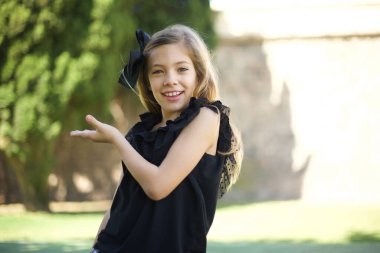 Siyah elbiseli güzel kız diyor ki: Vay be, ne kadar heyecan verici, hayret verici bir ifade, boş alanda boş elle bir şeyler gösteriyor. 